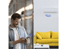 Charger l&#39;image dans la galerie, Homme avec téléphone contrôlant la clim, et clim sur mur blanc.
