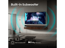 Charger l&#39;image dans la galerie, Salon avec TV affichant un batteur, comprend un caisson de basses intégré et Dolby Atmos.
