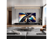 Charger l&#39;image dans la galerie, Un salon avec une grande télévision au mur et un canapé gris.
