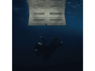 Une personne immergée dans l'eau, flottant sous une porte blanche. Fond bleu foncé.