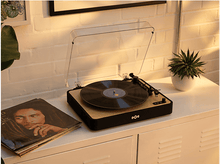 Charger l&#39;image dans la galerie, Une platine sur une table blanche. Un disque vinyle est sur le lecteur, à côté d&#39;une pochette.
