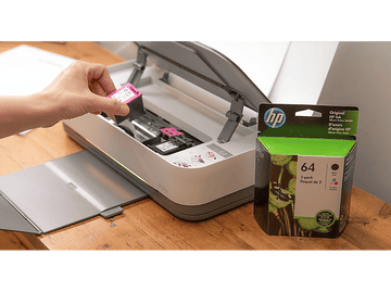 Une main insérant une cartouche d'encre rose et jaune dans une imprimante HP, à côté d'une boîte d'encre.