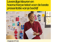 Charger l&#39;image dans la galerie, Une femme sourit en tenant un papier. Un mur avec des papiers et des chaussettes colorées est en arrière-plan.
