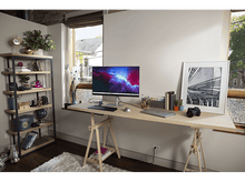 Charger l&#39;image dans la galerie, Un bureau avec un ordinateur, des livres et des décorations. Une étagère et une fenêtre sont en arrière-plan.
