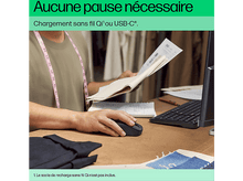Charger l&#39;image dans la galerie, Une personne utilise une souris d&#39;ordinateur noire sur un bureau en bois, avec du texte sur la recharge sans fil au-dessus.
