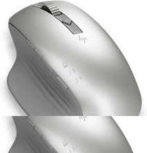 Charger l'image dans la galerie, Une souris d'ordinateur argentée avec un design ergonomique. Il y a des boutons et une molette de défilement.
