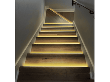 Charger l&#39;image dans la galerie, Escalier en bois avec lumières LED jaunes, menant vers le haut. Murs blancs et une rampe sont visibles.
