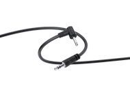 Câble audio noir avec deux prises jack de 3,5 mm et des connecteurs coudés. Le câble est sur un fond noir.