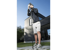 Charger l&#39;image dans la galerie, Un homme prenant des photos avec un appareil photo sur un trépied, ciel bleu en arrière-plan.
