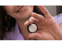 Charger l'image dans la galerie, Une femme tient un petit appareil rond avec le mot 'ISY'.
