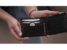 Charger l'image dans la galerie, Un portefeuille noir ouvert tenu par des mains. À l'intérieur se trouvent des cartes et un objet rond ISY.
