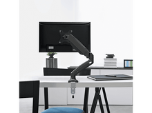 Charger l&#39;image dans la galerie, Bras de moniteur avec un moniteur noir sur un bureau blanc, contre un mur blanc.
