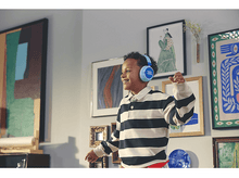 Charger l&#39;image dans la galerie, Un garçon portant un casque bleu sourit, danse. Images en arrière-plan.
