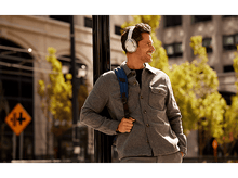 Charger l&#39;image dans la galerie, Homme avec un casque, un sac à dos, marchant dans une rue de la ville. Bâtiments et arbres en arrière-plan.
