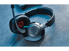 Charger l&#39;image dans la galerie, Casque de jeu JBL noir avec microphone. Le casque est sur une surface bleue texturée.
