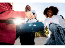 Charger l&#39;image dans la galerie, Trois personnes tiennent une enceinte JBL bleue avec le logo JBL, souriant à la caméra.
