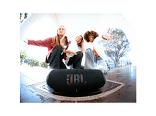 Charger l&#39;image dans la galerie, Trois jeunes souriant devant une enceinte JBL noire. L&#39;enceinte a un logo JBL rouge.
