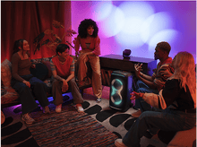 Charger l&#39;image dans la galerie, Groupe de personnes avec un haut-parleur. Ils sont dans une pièce avec des lumières.
