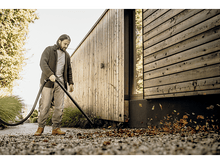 Charger l&#39;image dans la galerie, Un homme utilisant un aspirateur à feuilles pour nettoyer les feuilles sur un sol en pierre.
