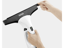 Charger l&#39;image dans la galerie, Des mains tiennent un nettoyeur de vitres blanc et noir. Une main touche la raclette noire.
