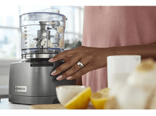 Charger l&#39;image dans la galerie, La main d&#39;une femme utilisant un robot culinaire avec des citrons et un bol au premier plan.
