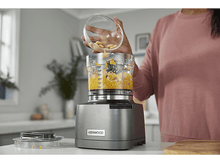 Charger l&#39;image dans la galerie, Une personne verse des haricots blancs d&#39;un bol en verre dans un robot culinaire.
