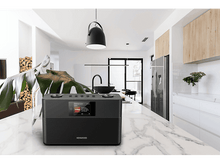 Charger l&#39;image dans la galerie, Radio Kenwood noire sur un comptoir blanc dans une scène de cuisine moderne.
