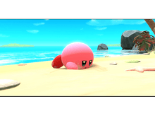 Charger l&#39;image dans la galerie, Un personnage rose de Kirby est partiellement enfoui dans le sable sur une plage.
