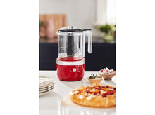Charger l&#39;image dans la galerie, Hachoir alimentaire KitchenAid rouge sur un comptoir avec une base rouge. Une tarte et des bols de nourriture sont au premier plan.
