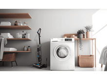 Charger l&#39;image dans la galerie, Un lave-linge, un aspirateur, des étagères et une table dans une pièce.
