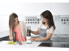 Charger l&#39;image dans la galerie, Deux femmes font un smoothie. Des raisins et des baies sont sur la table.
