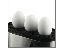 Charger l&#39;image dans la galerie, Trois œufs blancs sur une surface noire dans un cuiseur à œufs métallique, sur fond noir.
