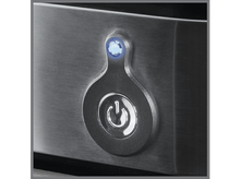 Charger l&#39;image dans la galerie, Bouton d&#39;alimentation avec une lueur bleue, sur une surface en métal brossé.
