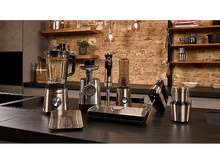 Charger l&#39;image dans la galerie, Appareils de cuisine sur un comptoir : blender, hachoir à viande, mixeur plongeant, batteur, balance et presse à panini.
