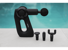Charger l&#39;image dans la galerie, Pistolet de massage noir avec accessoires sur surface blanche, fond d&#39;eau.
