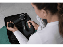 Charger l&#39;image dans la galerie, Femme tenant un pistolet de massage noir avec un étui noir ouvert à côté.
