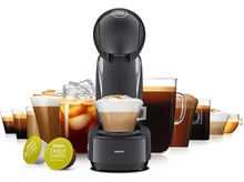 Charger l&#39;image dans la galerie, Une machine à café noire avec diverses tasses à café et capsules exposées sur fond blanc.
