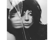 Photo en noir et blanc du visage d'une femme. Un morceau de verre est devant son visage.