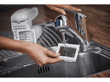 Charger l&#39;image dans la galerie, Une personne rinçant des bacs à glaçons sous un robinet de cuisine.
