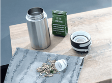 Charger l&#39;image dans la galerie, Bouteille d&#39;eau en acier inoxydable, ouverte, avec du thé et un sachet de thé vert.
