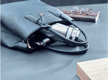 Charger l&#39;image dans la galerie, Main dans un sac à main avec une bouteille d&#39;eau et des lunettes.
