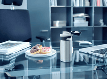 Charger l&#39;image dans la galerie, Bureau avec une bouteille d&#39;eau et deux beignets sur une assiette à côté d&#39;un ordinateur portable.
