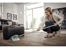 Charger l&#39;image dans la galerie, Une femme dans une pièce avec un sol en bois clair nettoie avec une serpillière. Elle sourit.
