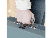Charger l&#39;image dans la galerie, Personne tenant une valise Lenco grise. Vêtue d&#39;une chemise blanche et d&#39;un jean.
