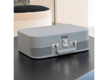Charger l&#39;image dans la galerie, Un tourne-disque Lenco gris en forme de valise fermée, sur une table noire. Des haut-parleurs sont visibles.
