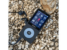 Charger l&#39;image dans la galerie, Un lecteur MP3 noir avec un écran et des écouteurs. Il est sur des petits galets bruns.
