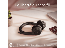 Charger l&#39;image dans la galerie, Casque noir sur une surface rose. Un ordinateur portable et un téléphone à proximité. Liberté sans fil.
