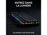 Clavier noir avec touches éclairées de différentes couleurs. Il est sur fond sombre avec du texte.