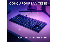 Charger l&#39;image dans la galerie, Un clavier noir avec rétroéclairage bleu, sur un bureau. Texte : CONÇU POUR LA VITESSE.
