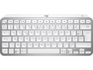 Clavier Logitech argenté avec touches blanches. Disposition QWERTY. Fond sombre.